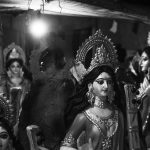 A collection of Hindu goddess statues in a dimly lit setting, enhancing their divine elegance.